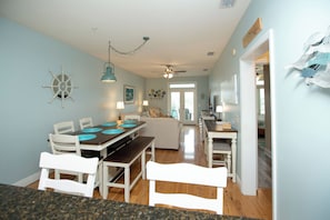 A dining area with a table, chairs, and a ceiling fan.