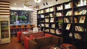 Una biblioteca acogedora con estanterías, una zona de estar y una máquina expendedora.