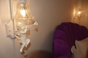 Una lámpara de pared con una figura decorativa de un ángel.