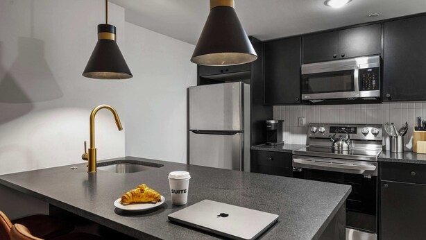 A modern kitchen with a central island, stainless steel appliances, and pendant lighting. - Sosuite | 2BR Apt w Laundry, Private Entrance (Philadelphia)