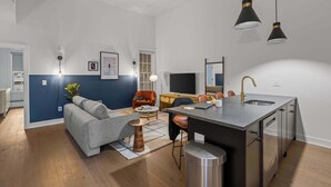 A modern apartment with a kitchen, dining area, and living room.