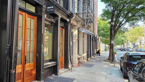 A street view with a building labeled 'SUITE The Loxley' with large windows, a fire hydrant, and parked cars. - Sosuite | Studio Apt w Laundry, Courtyard View (Philadelphia)