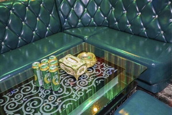 A green upholstered sofa with a glass coffee table. - Guangzhou Conghua Hot SpringXingKong Selected Holiday Villa (Guangzhou)