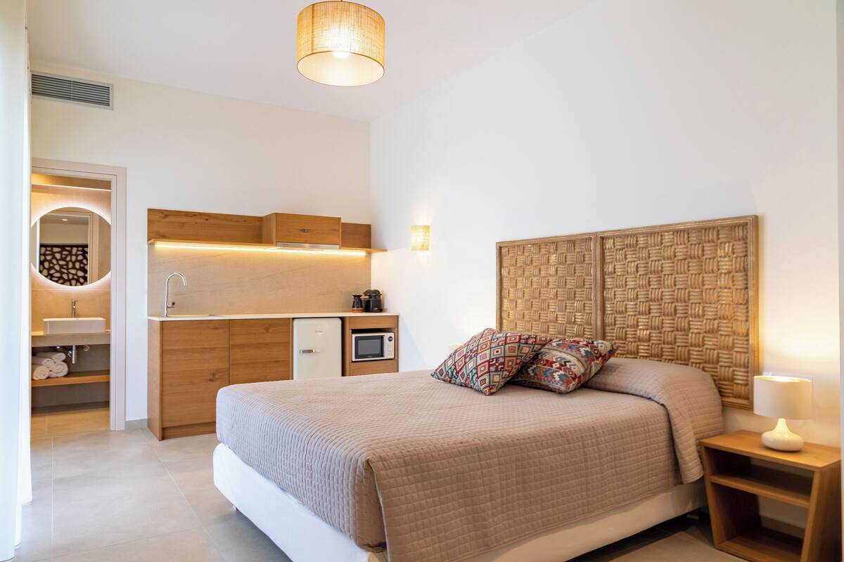 Une chambre à coucher comprenant un lit, une table de chevet et une petite kitchenette.