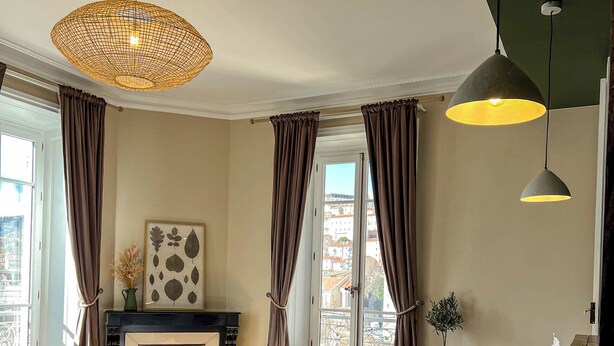Un dormitorio con una cama grande, una chimenea, una mesa de comedor y vistas a la ciudad.
