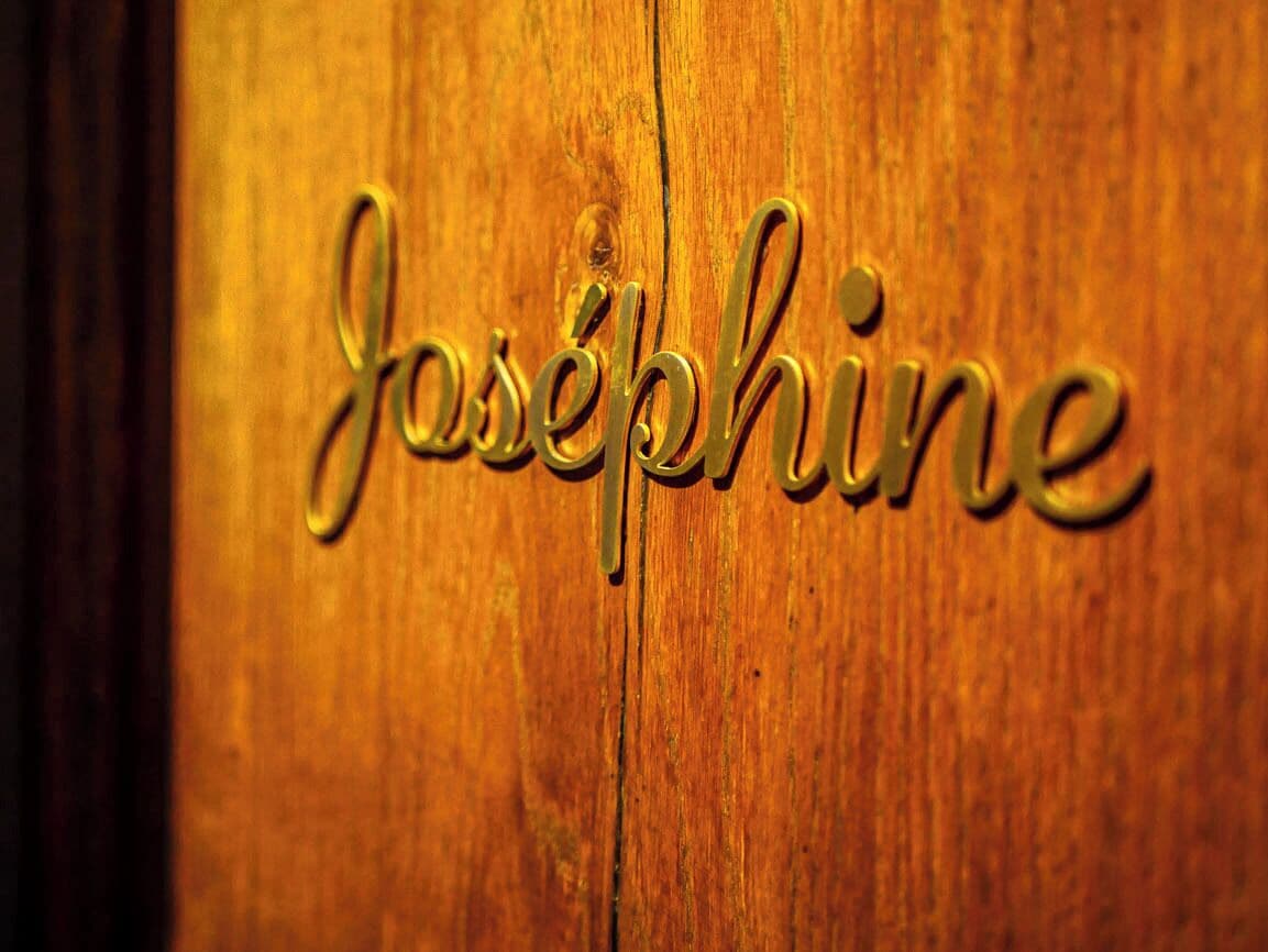 A wooden surface with the name "Josephine" engraved in a cursive, metallic font.