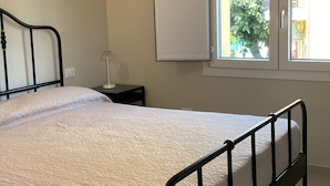 A bedroom with a bed, a nightstand, a window, and a door. - B&B CIVICO 33 (Scalea)