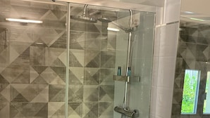 A modern bathroom with a glass shower enclosure, a white sink, and a large mirror. - B&B CIVICO 33 (Scalea)