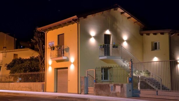 A two-story building with a balcony on the upper floor, a gated entrance, and a staircase leading to the upper level. - B&B CIVICO 33 (Scalea)