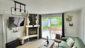 Ett modernt vardagsrum med en öppen spis, ett matbord och en soffa.