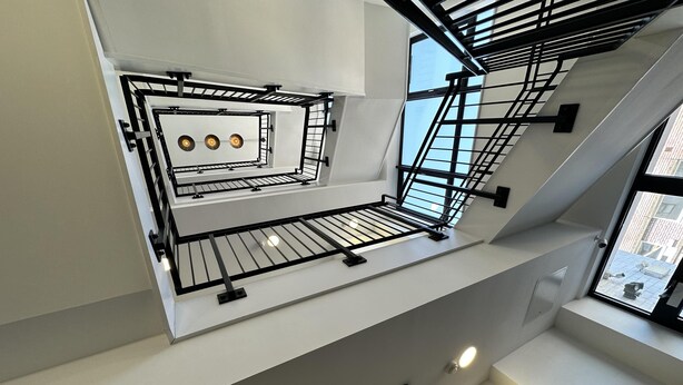 A multi-level interior with a staircase, a mezzanine with a railing, and a ceiling light fixture. - Condo Apartment With Workspace (Haywards Heath)