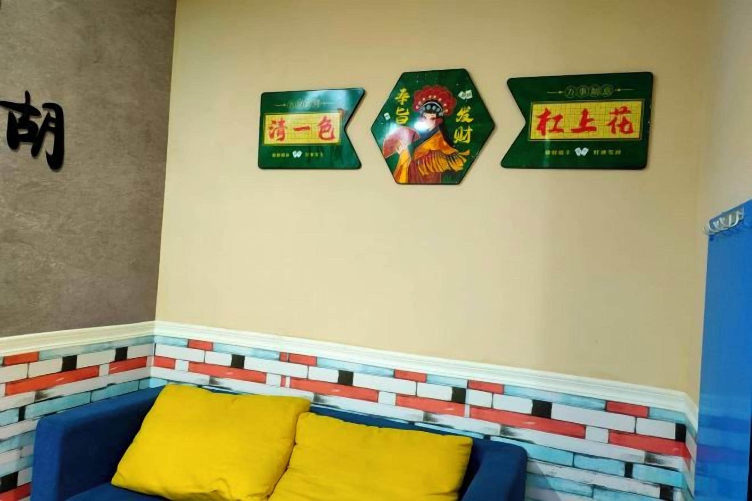 A room with a blue couch, a brick-patterned wall, and three green signs with Chinese characters.