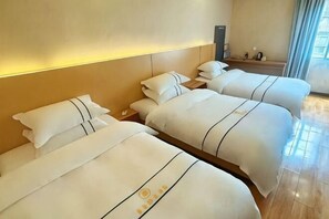 A hotel room with three beds, a nightstand, a lamp, and a window with curtains. - Sherage Hotel (Emeishan City)