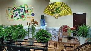 Une pièce avec une fresque murale, un ventilateur et plusieurs plantes en pot.