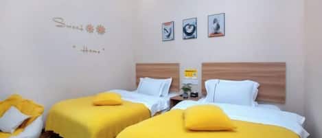 A hotel room with two beds, a small seating area, and artwork on the wall.