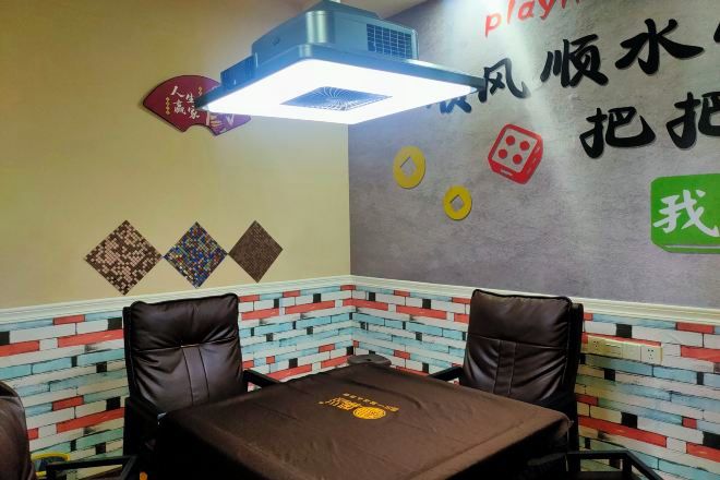 Interior de restaurante con pared de ladrillo, ventilador de techo y mesa con mantel marrón.