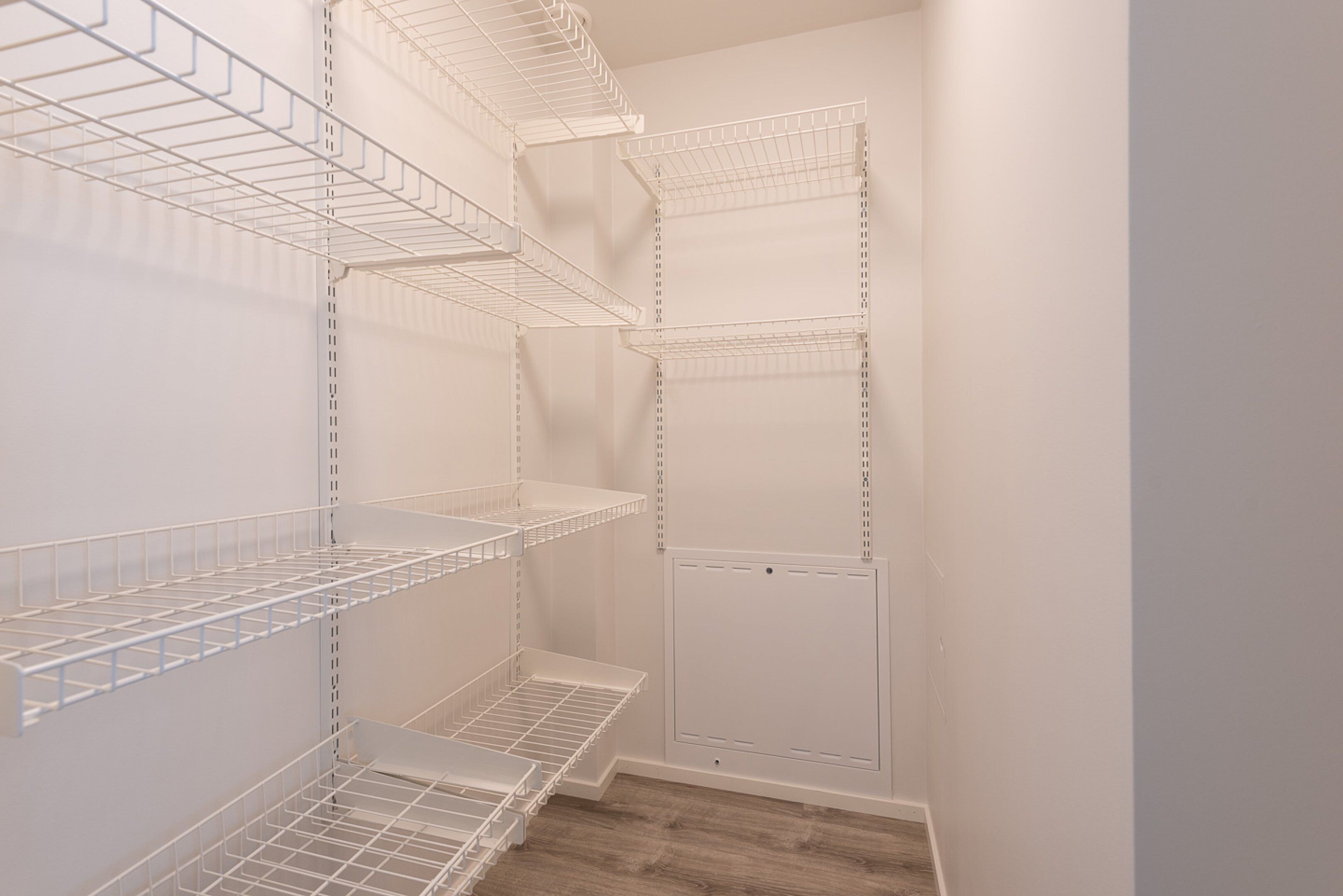 A walk-in closet with multiple wire shelves and a door.