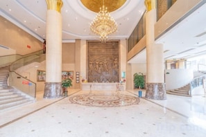 A spacious lobby with a grand chandelier, marble columns, and a central decorative wall. - Vienna Hotel (Foshan West Railway Station Airport Branch) (Foshan)