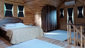 A wooden cabin bedroom with a bed, wardrobe, and a small table. - DIAMOND TREE HOUSE (Maçka)