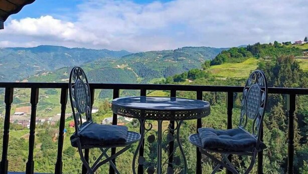 A balcony with two chairs and a table, overlooking a mountainous landscape. - DIAMOND TREE HOUSE (Maçka)