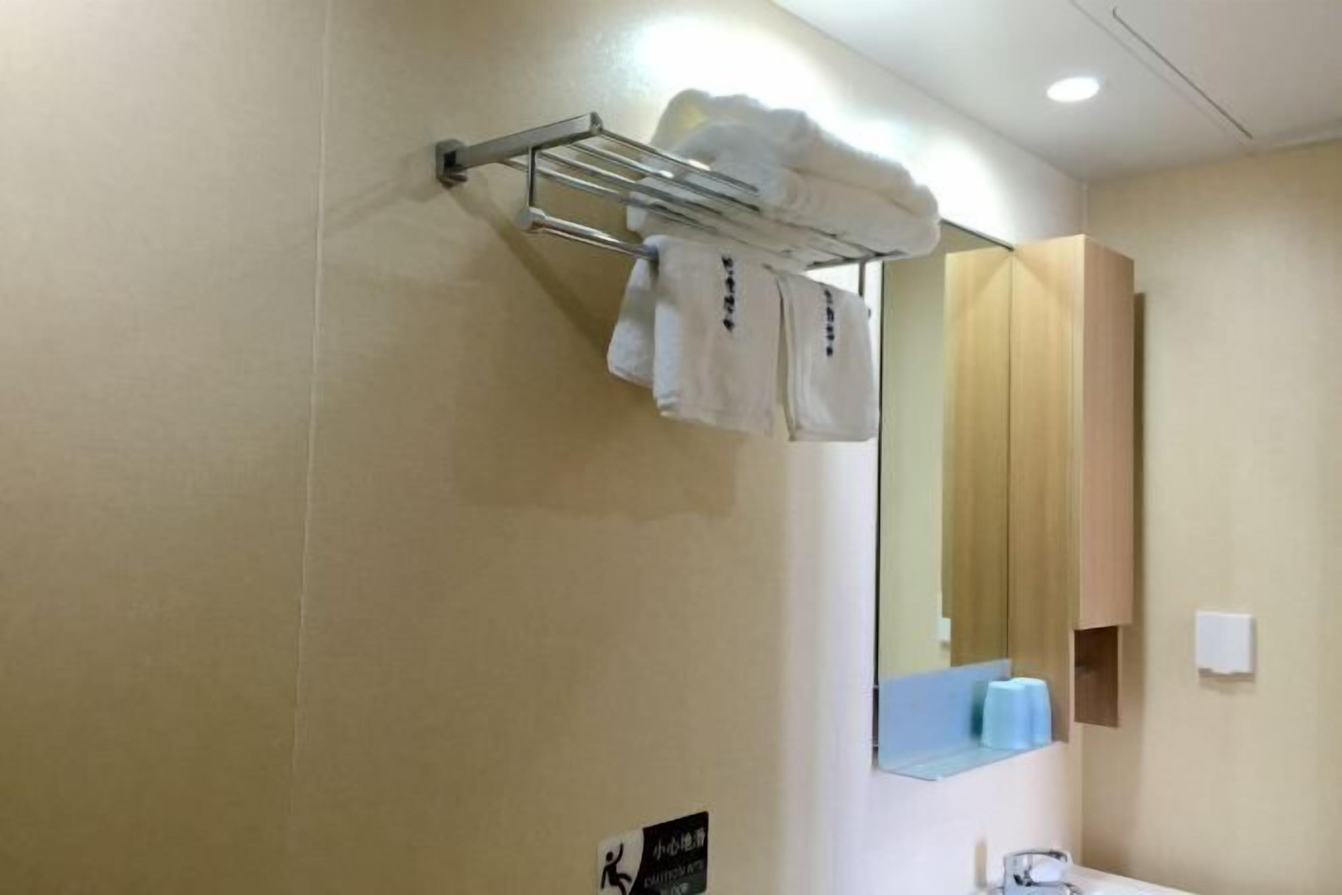 Un baño con toallero, espejo y lavabo.