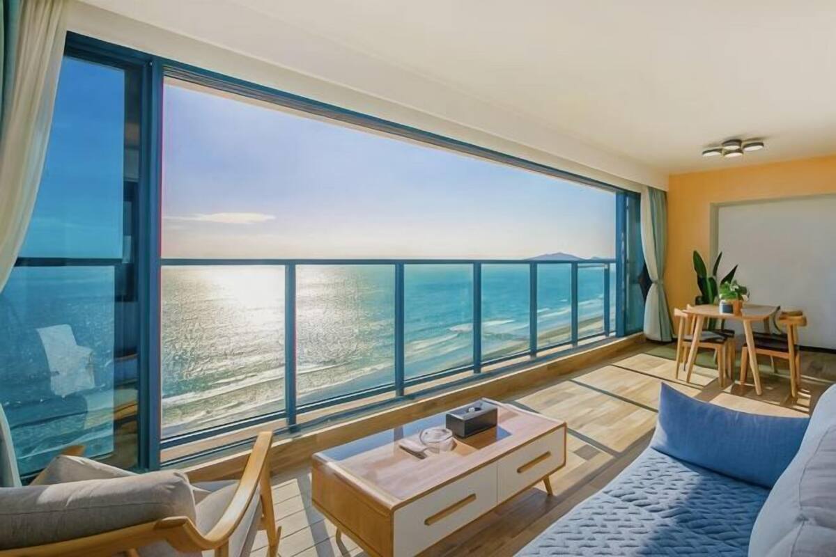 Un balcón con vista al mar, un comedor y un sofá.