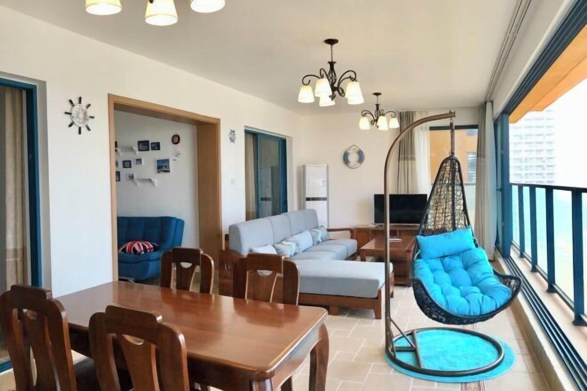 Ein modernes Wohnzimmer mit Essbereich, einem Hängekorbstuhl und einem Balkon mit Blick.