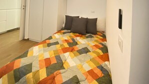 Une chambre à coucher avec un grand lit, des murs blancs et un plafond en bois.