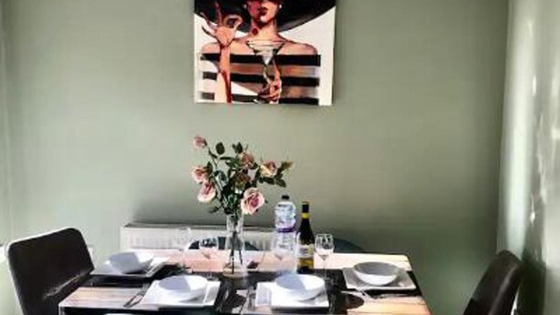 A dining area with a table set for four, a vase with flowers, and a painting on the wall. - Stunning 3-bed House in Bristol (Bristol)