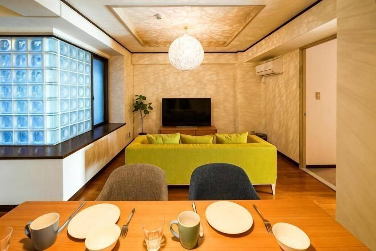 A modern living room with a sofa, dining table, and TV.