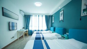 A hotel room with two beds, a desk, and a TV. - Tianchen Villa (Shengsi)