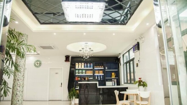 A modern interior with a reception desk, seating area, and a chandelier. - Tianchen Villa (Shengsi)