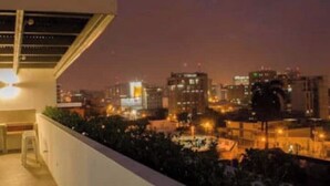 Une terrasse sur le toit offrant une vue sur la ville la nuit.