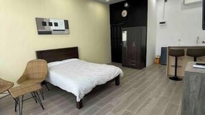 Un dormitorio moderno con cama, escritorio y armario.