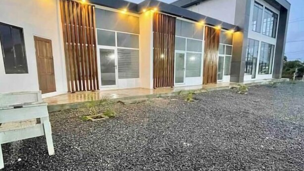 Un edificio moderno con amplias ventanas y un camino de grava.