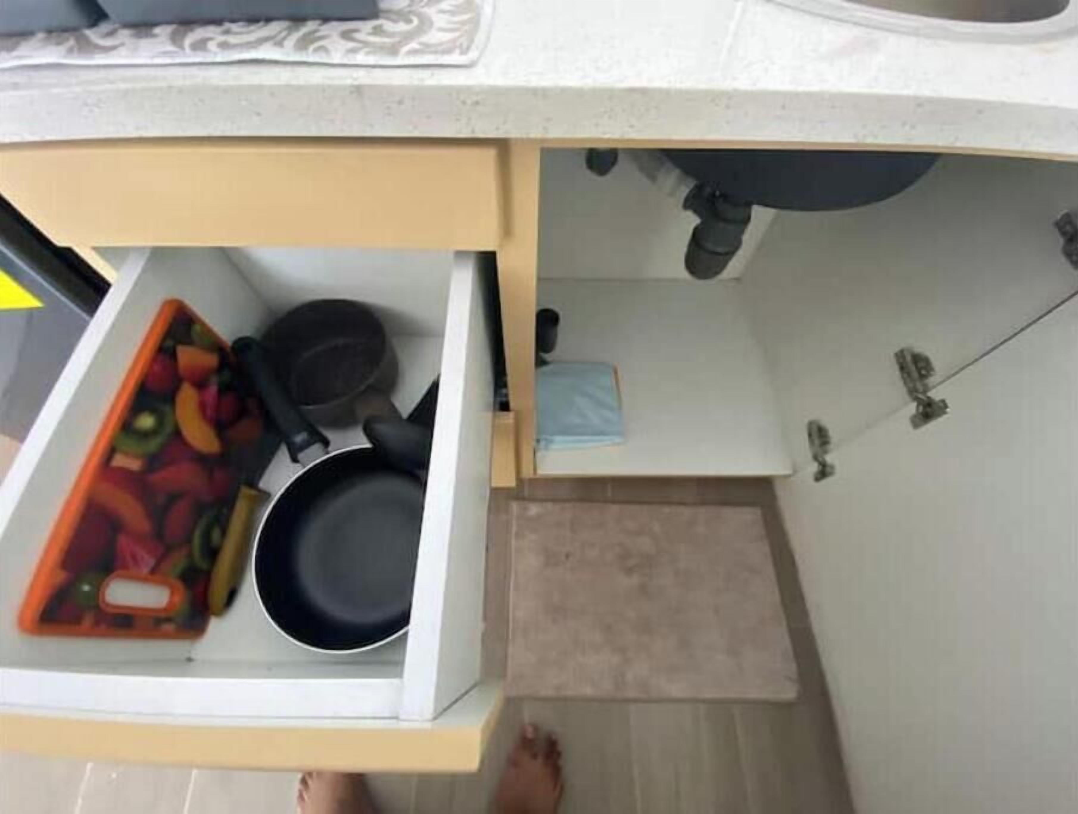 Eine Küche mit Arbeitsplatte, einer Schublade und einem kleinen Regal.