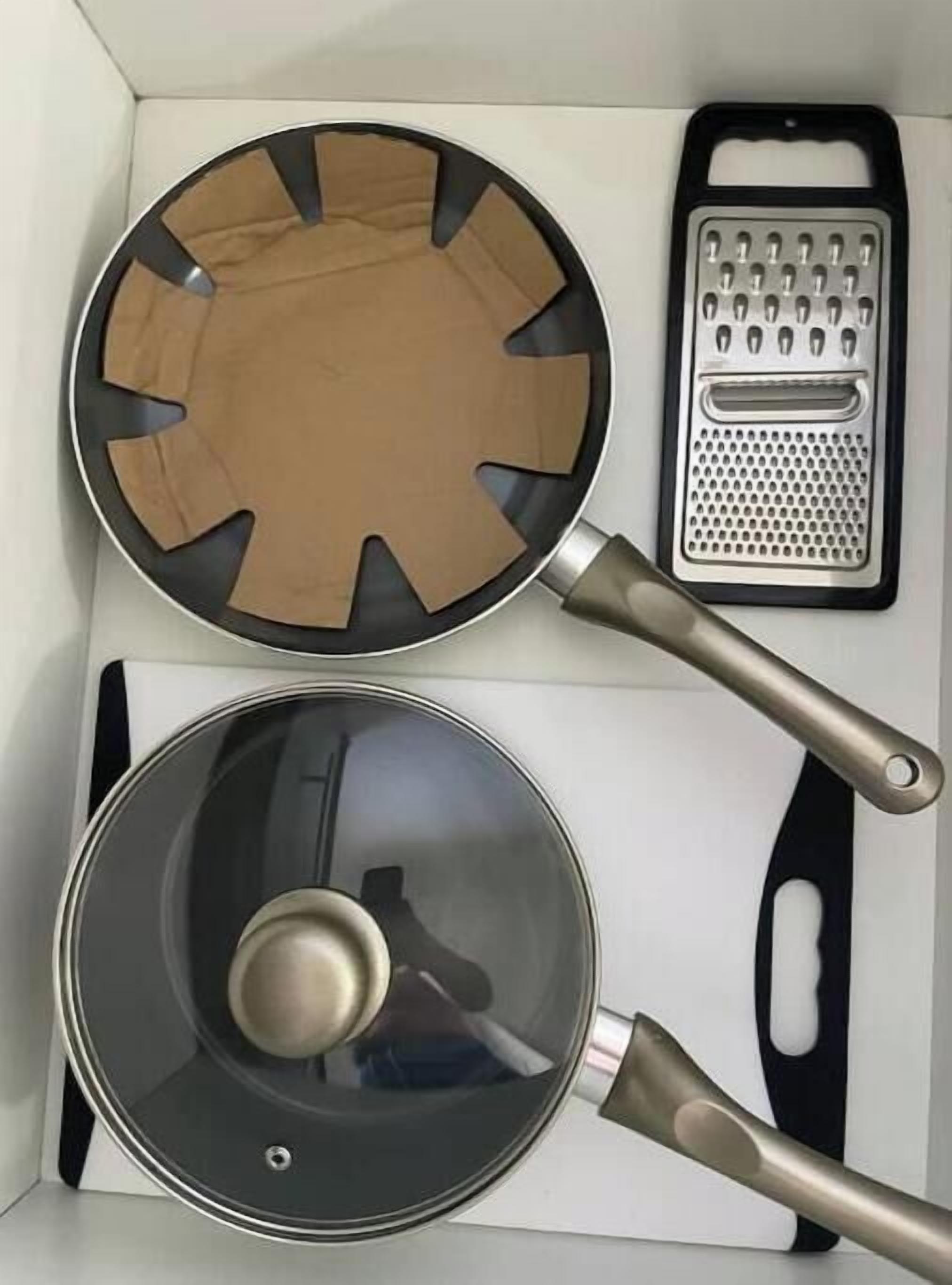 Uma cozinha com uma frigideira, ralador e panela.