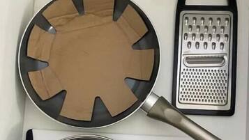 Uma cozinha com uma frigideira, ralador e panela.