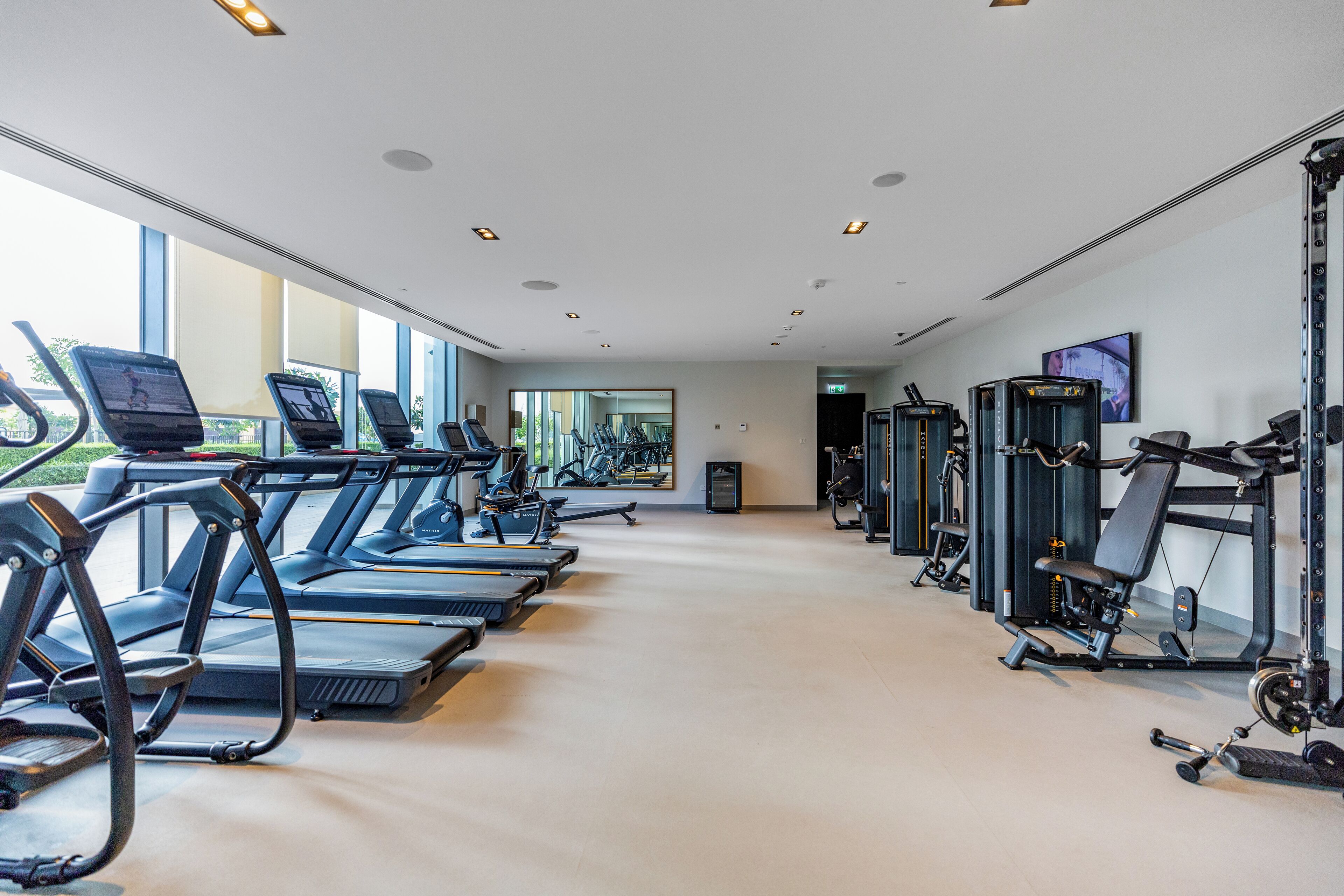 Una palestra con tapis roulant, ellittiche e attrezzi per pesi.