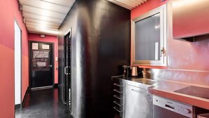 Una cocina moderna con electrodomésticos de acero inoxidable, lavavajillas y un ventanal grande.