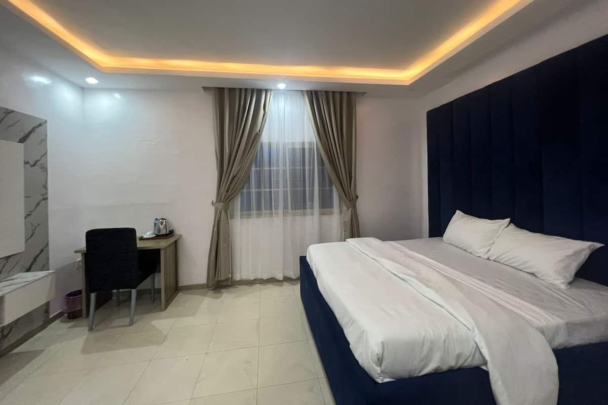 Una habitación de hotel con cama, escritorio y una silla.