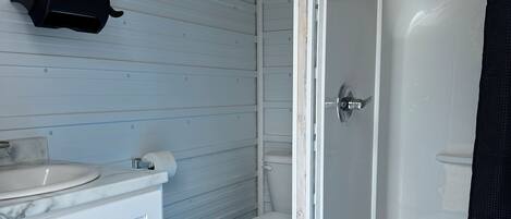 A bathroom with a white sink, toilet, and shower.