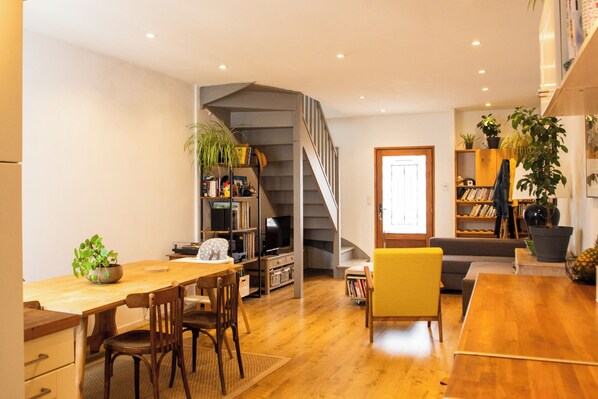Relax in a spacious living area with a dining table, sofa, and bookshelves.