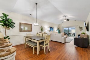 A spacious living area with a dining table, sofas, and a balcony with a view. - Waterview Lux Golf 3 Bdrm- Pools- Broadway @ Beach (Myrtle Beach)