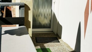 A small outdoor area with a door, a bench, and a small table. - L'appart D'angélique (Imling)