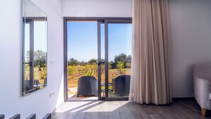 Une chambre moderne dotée d’une porte-fenêtre coulissante donnant sur un espace extérieur, ainsi que d’une petite table et d’une chaise.