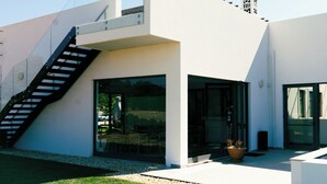 Un bâtiment moderne doté d’une façade en verre, d’un escalier et d’une petite tour.