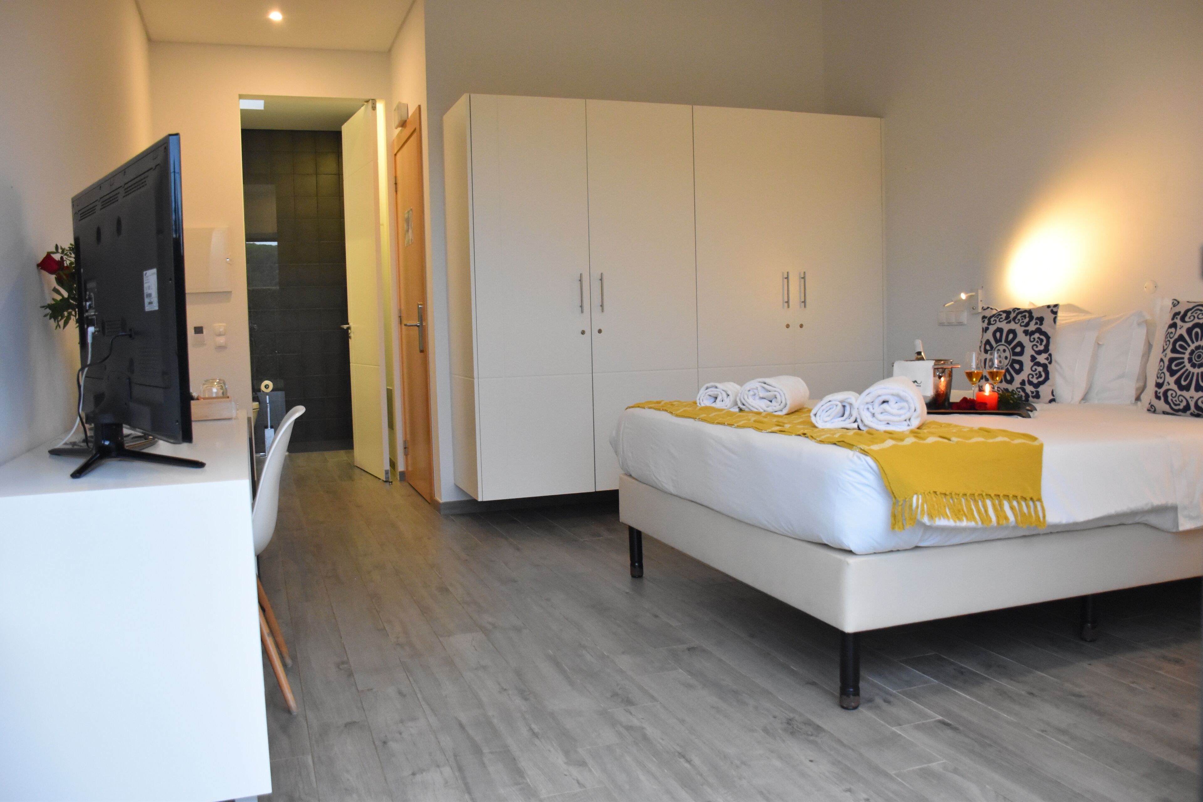 Ein modernes Hotelzimmer mit Bett, Schreibtisch und Kleiderschrank.