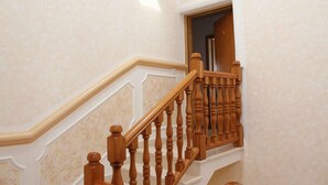 Een houten trap met een witte balustrade en een deur aan de bovenkant.