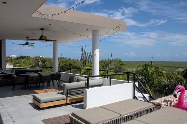 An outdoor patio with seating, a dining area, and a view of the landscape. - Luxury Villa Incl Pool With Seaview Near Beaches (Grote Berg)